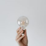 Smart Lighting - Anonymous female showing light bulb