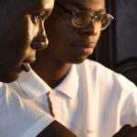 Translation Devices - Two young men are working on a laptop